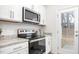 Modern kitchen features white cabinets, stainless steel appliances, granite countertops, and backyard access at 2832 Egert Dr, Haw River, NC 27258