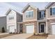 Townhome with tan siding, brick accents, a one-car garage, and a covered front entryway at 2834 Egert Dr, Haw River, NC 27258