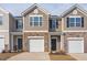 Townhome with tan siding, brick accents, a one-car garage, and a covered front entryway at 2834 Egert Dr, Haw River, NC 27258