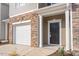 Close up of the front entryway, garage, and landscaping of a townhome at 2834 Egert Dr, Haw River, NC 27258