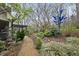 Landscaped backyard features a gravel path, various bushes, and a pergola at 3001 Hunters Bluff Dr, Raleigh, NC 27606