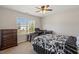Bright bedroom with ceiling fan, large window, dresser, and desk setup; perfect for work or study at 3007 Cardinal Lake Dr, Durham, NC 27704