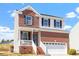 Traditional two-story home featuring brick accents, vinyl siding, a two-car garage, and a cozy front porch at 3007 Cardinal Lake Dr, Durham, NC 27704