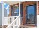 Inviting front porch showcasing brickwork, white railings, and a stylish front door with glass detail at 3007 Cardinal Lake Dr, Durham, NC 27704
