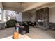 Covered patio with stone fireplace, seating area and ceiling fan; ideal for outdoor entertaining or relaxation at 303 Fortress Dr, Morrisville, NC 27560