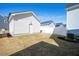 Backyard view with a lawn, white fencing, and a detached garage matching the home's exterior at 305 Wash Hollow Dr, Wendell, NC 27591
