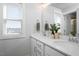 Modern bathroom with double sinks, white cabinets, quartz countertops, and ample natural light at 305 Wash Hollow Dr, Wendell, NC 27591