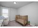 Cozy bedroom with a crib, rocking chair, and soft natural light from a window at 305 Wash Hollow Dr, Wendell, NC 27591