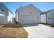 Image showcases a detached garage with a concrete driveway and manicured landscaping surrounding the structure at 305 Wash Hollow Dr, Wendell, NC 27591