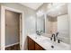 Bathroom vanity featuring dual sinks, modern fixtures, and a shower/tub combination in the background at 317 Michigan Ave, Cary, NC 27519