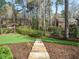 Stone stairs lead to a backyard with mature trees and lush grass, inviting outdoor enjoyment at 3321 Marblehead Ln, Raleigh, NC 27612
