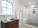 Bright bathroom featuring a tiled shower with a glass door, complemented by a classic vanity with elegant fixtures at 3321 Marblehead Ln, Raleigh, NC 27612