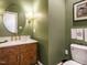 Stylish bathroom with a decorative mirror, wood vanity, and green walls at 3321 Marblehead Ln, Raleigh, NC 27612