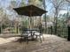 Outdoor deck with a dining set shaded by a large umbrella, surrounded by lush trees at 3321 Marblehead Ln, Raleigh, NC 27612