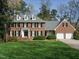 Classic brick two-story home featuring dormer windows, black shutters, and a meticulously maintained front lawn at 3321 Marblehead Ln, Raleigh, NC 27612