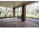 Covered patio with brick flooring and columns, offering an outdoor retreat surrounded by trees at 3321 Marblehead Ln, Raleigh, NC 27612