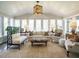 Sun-drenched sunroom with multiple windows, comfortable seating, and a decorative chandelier, offering serene views at 3321 Marblehead Ln, Raleigh, NC 27612