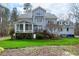 Expansive backyard featuring lush green grass, mature trees, a patio, and a sunroom at 3424 Forest Oaks Dr, Chapel Hill, NC 27514