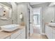 Bathroom with neutral walls featuring dual floating sinks, stone countertops and access to the bedroom at 3424 Forest Oaks Dr, Chapel Hill, NC 27514