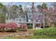 Charming two-story home featuring a classic design, blooming flowers, and a vibrant red front door at 3424 Forest Oaks Dr, Chapel Hill, NC 27514