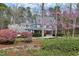 Charming two-story home with a red door, blooming trees, and beautiful stone wall, landscaped for privacy at 3424 Forest Oaks Dr, Chapel Hill, NC 27514