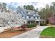 Charming two-story home with landscaped yard, blooming tree, and inviting front porch and red front door at 3424 Forest Oaks Dr, Chapel Hill, NC 27514