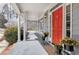 Inviting front porch with a vibrant red door, classic columns, and potted plants at 3424 Forest Oaks Dr, Chapel Hill, NC 27514