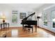 Bright living room with hardwood floors, grand piano, and ample natural light at 3424 Forest Oaks Dr, Chapel Hill, NC 27514