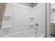 Clean white bathroom with a tub and shower combination, complete with built-in shelving at 3502 Pelican Ln, Durham, NC 27703