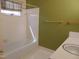 A bathroom featuring a bathtub, toilet, sink, and a green accent wall at 3601 Colonial Ln, Rocky Mount, NC 27804