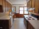 Traditional kitchen with wooden cabinetry, double basin sink, window, and classic appliances at 3601 Colonial Ln, Rocky Mount, NC 27804