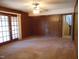 Spacious living room featuring paneled walls and natural light from sliding glass doors at 3601 Colonial Ln, Rocky Mount, NC 27804
