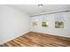 This bedroom has wood-look flooring, blinds, and neutral walls at 3615 Ramblewood Ave, Durham, NC 27713