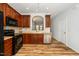 Bright kitchen features wood cabinets, black appliances, and stainless steel dishwasher at 3615 Ramblewood Ave, Durham, NC 27713