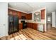 This kitchen features wood cabinets, black appliances, wood-look flooring, and stainless steel dishwasher at 3615 Ramblewood Ave, Durham, NC 27713