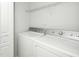 Well-lit laundry room includes a white washer and dryer and overhead storage shelf at 3615 Ramblewood Ave, Durham, NC 27713