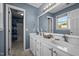 Bathroom featuring double sinks, a large mirror, vanity lights, and blue wall paint at 4 Applewood Sq, Durham, NC 27713