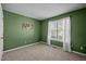 A bedroom featuring neutral carpet, light-filtering blinds, a window and green colored walls at 4 Applewood Sq, Durham, NC 27713