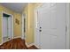 View of a home's entryway featuring yellow walls, hardwood flooring, and white doors at 4 Applewood Sq, Durham, NC 27713