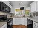 A well-lit kitchen features stainless steel appliances, white cabinets, granite countertops, and a tile backsplash at 4 Applewood Sq, Durham, NC 27713