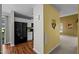 View of kitchen with white cabinets, black appliances, and hardwood floors from the hallway at 4 Applewood Sq, Durham, NC 27713