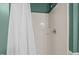 Shower with white showerhead and semi-transparent shower curtain with bright green wall paint at 4 Applewood Sq, Durham, NC 27713
