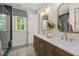 Bright bathroom with double sinks, quartz counters, and a glass shower enclosure at 4706 Cypress Tree Ln, Raleigh, NC 27612