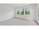 Bright bedroom features three large windows and neutral carpeting at 4706 Cypress Tree Ln, Raleigh, NC 27612