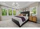 Serene bedroom boasts large windows, tray ceiling, and a cozy bed with decorative pillows at 4706 Cypress Tree Ln, Raleigh, NC 27612