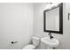 Modern half-bathroom has pedestal sink and matte black hardware at 4706 Cypress Tree Ln, Raleigh, NC 27612