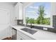Modern kitchen sink featuring a stainless steel sink and view of the backyard at 4706 Cypress Tree Ln, Raleigh, NC 27612
