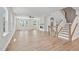 Bright living room featuring hardwood floors, fireplace, fan, and wooden staircase at 4706 Cypress Tree Ln, Raleigh, NC 27612