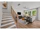 Open concept living area with staircase, large windows, and comfortable seating at 4706 Cypress Tree Ln, Raleigh, NC 27612