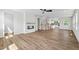 Open-concept living room featuring hardwood floors, fireplace, fan, and staircase to the second floor at 4706 Cypress Tree Ln, Raleigh, NC 27612
